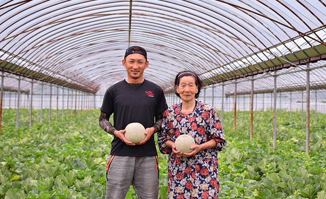 『大玉赤メロン』の栽培農家、長松農園の長松亮太さんとお婆様。美味しいメロンの育て方を研究するために日々メロンと向き合ってご家族でメロン栽培を行っています。